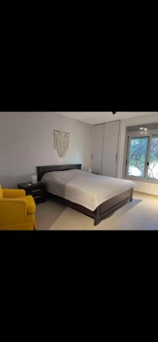 a bedroom with a bed and a yellow chair at Your Getaway to Adventure in Ain Sokhna