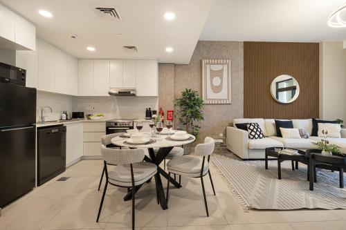 a kitchen and living room with a table and chairs at Elegant Stay with Pool & Gym Near Iconic Landmarks in Dubai