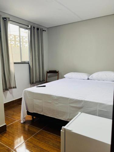 a bedroom with a white bed and a window at Hotel e Restaurante Casa Velha in Barra Longa
