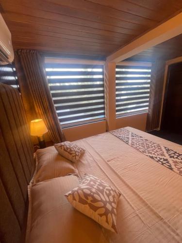 a bedroom with two beds and two windows at Airport waterfront chalet in Katunayake