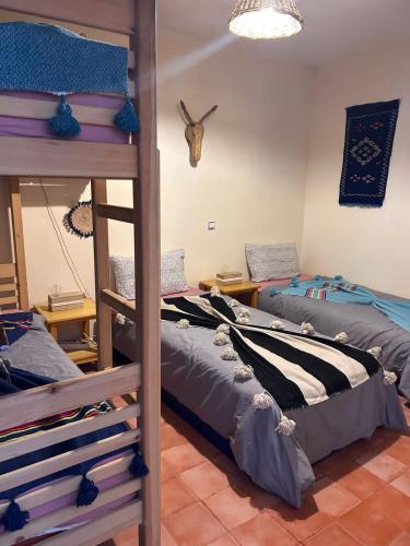 a room with two bunk beds at Tigmi Blue - Imsouane Surf et Océan in Imsouane