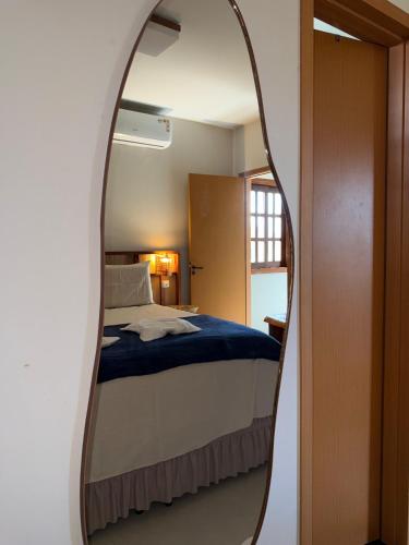 a bedroom with a bed and a mirror at Paraíso dos Lençóis casa 08 Atins in Atins