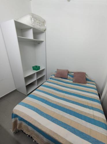 a bedroom with a bed with a striped blanket at Comfortable and practical house in Asuncion