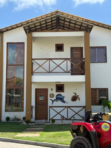 a house with a red motorcycle parked in front of it at Paraíso dos Lençóis casa 08 Atins in Atins