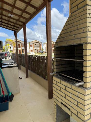 a brick oven on a patio with a fence at Paraíso dos Lençóis casa 08 Atins in Atins