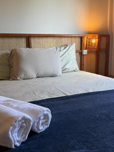 a bed with white sheets and pillows in a room at Paraíso dos Lençóis casa 08 Atins in Atins