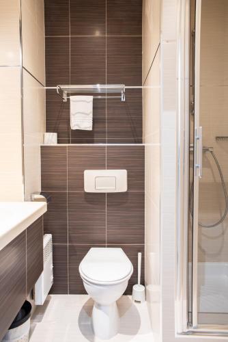 a bathroom with a toilet and a shower at Hôtel Garabel in Plaisir