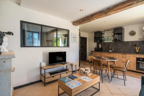 un salon avec une table et une cuisine dans l'établissement Napoléon, à Saint-Genis-de-Saintonge