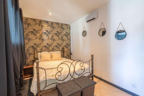 ein kleines Schlafzimmer mit einem Bett und einer Wand in der Unterkunft Napoléon in Saint-Genis-de-Saintonge