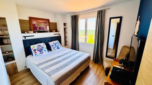 une petite chambre avec un lit et une fenêtre dans l'établissement Charme méditerranéen Terrasse féerique et vue mer, à Ramatuelle