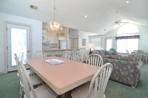 ein Esszimmer und ein Wohnzimmer mit einem Tisch und einem Sofa in der Unterkunft Seaside 58 by Village Realty in Nags Head