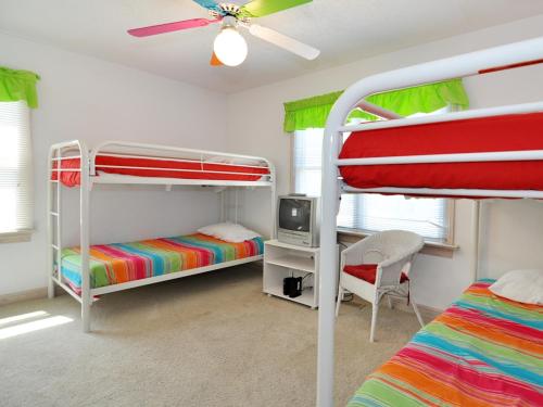 1 Schlafzimmer mit 2 Etagenbetten und einem Deckenventilator in der Unterkunft Seaside 58 by Village Realty in Nags Head
