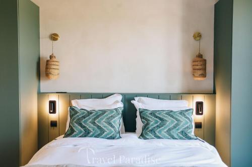 a bedroom with a bed with two pillows at Villa du Phare in Saint-Clément-des-Baleines