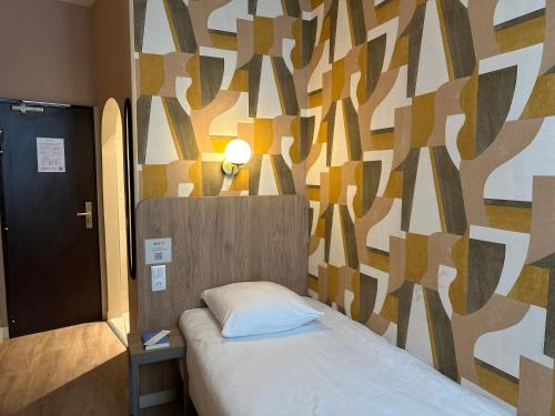 a bedroom with a bed and a wall with a tree pattern at Merryl Hotel in Paris