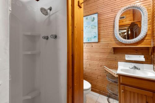 a bathroom with a toilet and a sink and a mirror at Seasons in the Sun in Nags Head