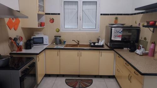 a small kitchen with a sink and a microwave at Villa Bellevue in Sainte-Rose