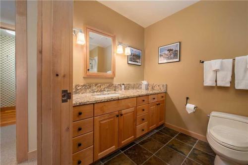 a bathroom with a toilet and a sink and a mirror at RMR: Cody House B Condo in Teton Village in Teton Village