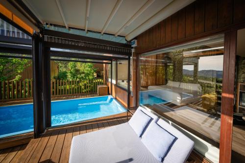 a room with a swimming pool and a balcony with a tub at Nidos de carnota in Carnota