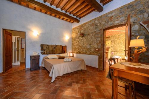 a bedroom with a bed and a table in a room at La Landuccia in Libbiano