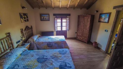 a bedroom with two beds and a window at Casa rural Tío Quico in Granja de Moreruela