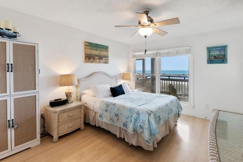 Un dormitorio con una cama y un balcón con vista al mar. en Shyers Luck, en Kill Devil Hills