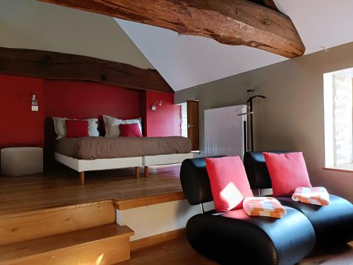 a bedroom with a bed and a couch and chairs at La Ferme Aux Arts in Beaumont-sur-Grosne