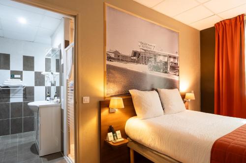 a hotel room with a bed and a bathroom at Logis Hôtels et restaurant La Pause Rn7 in La Coucourde