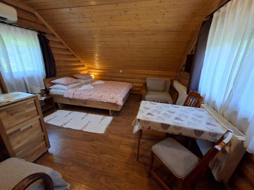 an attic room with two beds and a table and chairs at Rönkházacska - Kétkerék Vendégház in Mátraszentimre
