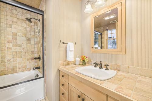 a bathroom with a sink and a tub and a mirror at RMR: Cody House D Condo in Teton Village in Teton Village