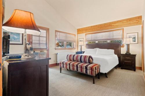 a bedroom with a bed and a chair and a lamp at RMR: The Village House in Teton Village in Teton Village