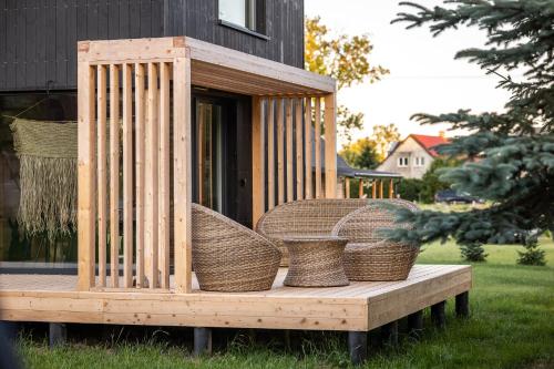 a wooden house with wicker baskets on a deck at KJM - Leśna Przystań in Myślęcin