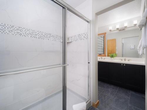 Un baño con ducha de cristal y lavabo. en RMR: Windflower 2121 Condo in The AspensWilsonWY, en Wilson