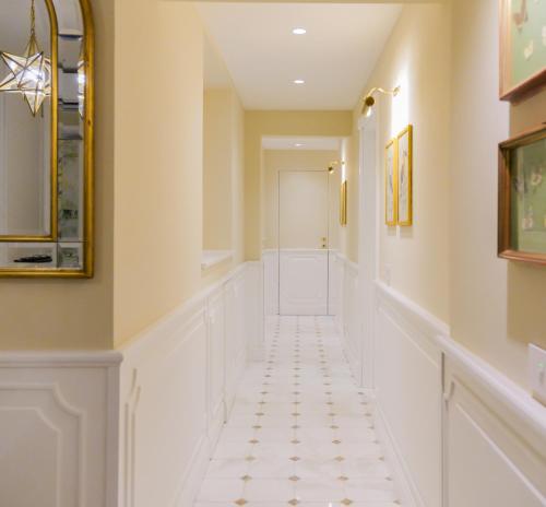 a hallway with white tile flooring and a long corridor at Dimora del Mercante - Luxury rooms in Florence