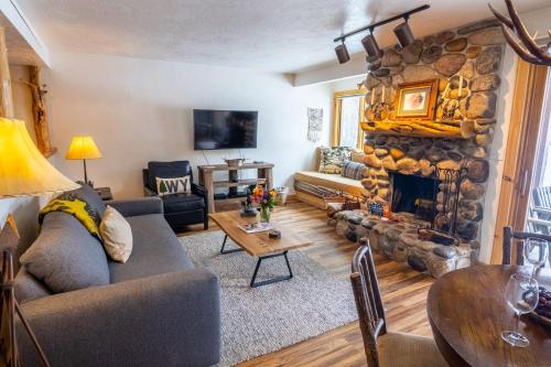 a living room with a couch and a fireplace at RMR: Cedars 1412 Condo in The AspensWilson WY in Wilson