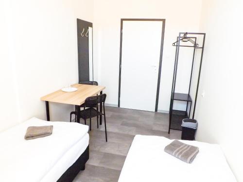 a room with two beds and a table and a mirror at Nice room E3 Prague 7 in Prague