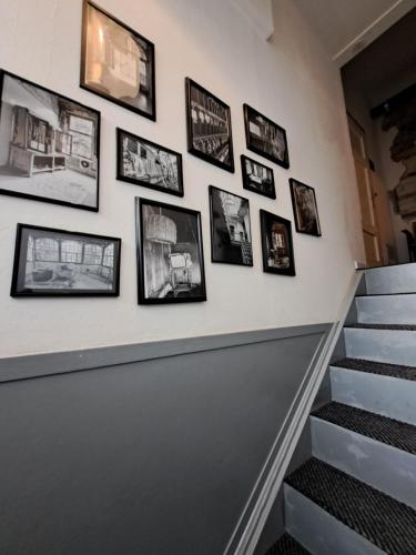 a wall of pictures on a stairway with a stair case at Pension Holl und Boll Am Hexenstieg. in Clausthal-Zellerfeld