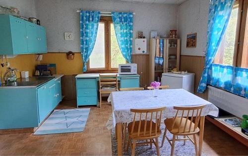 a kitchen with blue cabinets and a table and chairs at Villa Vintage in Tammela