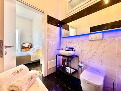 a bathroom with a sink and a toilet in a room at Villa Nauna, fronte mare con giardino e terrazzo - Marea Stays Collection in Nardò