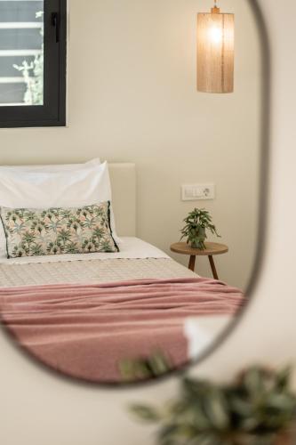 a bedroom with a bed with a pillow and a mirror at Petra Natura Villa in Zakynthos Town