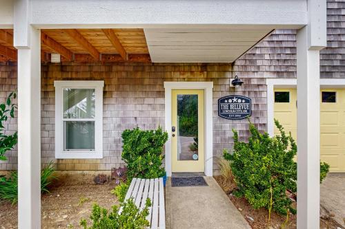 a house with a yellow door and a sign on it at The Bellevue in Lincoln City