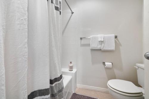 a white bathroom with a shower curtain and a toilet at RMR: Mountain Maple 4 Condo in The Aspens in Wilson