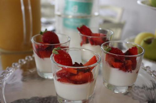 four glasses of dessert with strawberries on a glass plate at Hotel Clodia - Adults Only in Sirmione