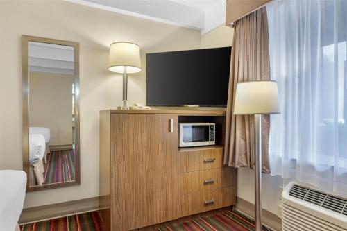 a hotel room with a flat screen tv on a cabinet at Best Western El Rancho Palacio in Roswell