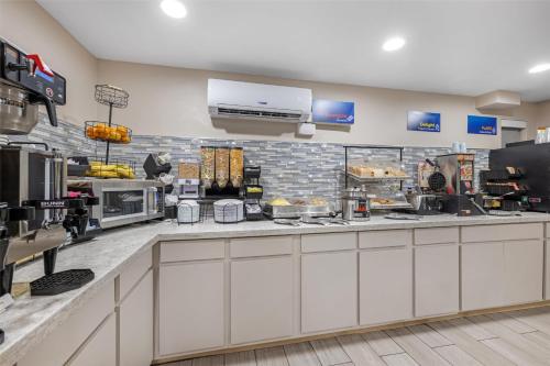 a restaurant kitchen with a counter with food at Best Western El Rancho Palacio in Roswell