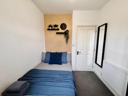 WembleyにあるConvenient Private Single Room 30 Min to Centralの青いベッドとドア付きの小さなベッドルーム1室が備わります。