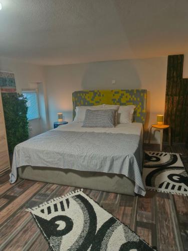 a bedroom with a bed and two rugs at ColoR Living - loft & yard in Karditsa