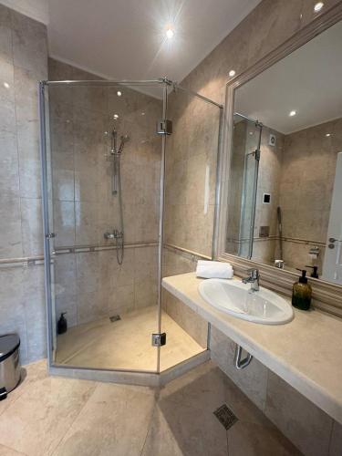 a bathroom with a glass shower and a sink at On the sand near the sea in Varna City