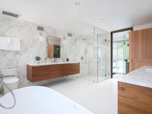 a white bathroom with a shower and a sink at RMR: Montreux House in Teton Village in Teton Village