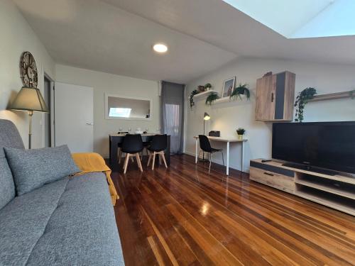 a living room with a couch and a flat screen tv at CÉNTRICO ÁTICO Solares RH-10 in Solares