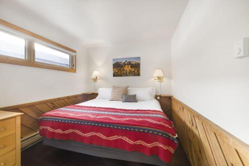 ウィルソンにあるRMR: Hawthorne 214 Condo in The AspensWilsonWYの赤い毛布が掛けられた大きなベッドのある寝室